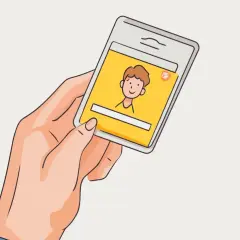 Dłoń trzyma smartfon z żółtym ekranem, na którym widnieje rysunkowa postać. Szybki kredyt na tak przez telefon.