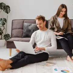 Para młodych planuje swoje wymarzone mieszkanie na start, korzystając z laptopa i tabletu.