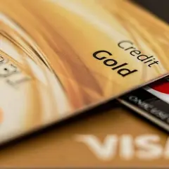 Złota karta kredytowa z napisem "Gold" i numerem 0031. Pod nią widać karty Visa i Mastercard. To przykład, co to kredyt odnawialny.