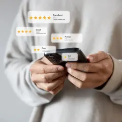 Osoba trzymająca smartfon sprawdza opinie o firmie, analizując oceny od "Bad" do "Excellent". To pokazuje, jak sprawdzić wierzytelność firmy.