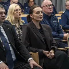 Ludzie w mundurach policyjnych i cywilnych ubraniach siedzą na sali. Dowiedz się, jak sprawdzić numer sprawy na policji.