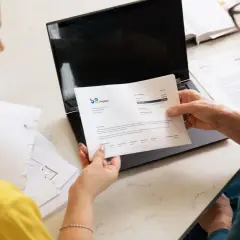 Dwie kobiety analizują dokumenty, szukając rozwiązania, być może ostatniego kredytu dla zadłużonych.