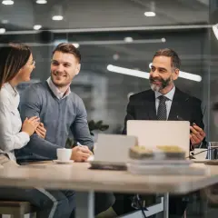Para, która planuje wspólny kredyt bez ślubu, omawia szczegóły z doradcą. Uśmiechnięci, patrzą na siebie z nadzieją.
