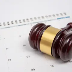 Młotek sędziowski na kalendarzu symbolizuje czas, po jakim przedawniają się długi bankowe.
