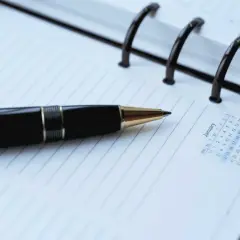 Czarny długopis na kalendarzu. Planujesz, jak usunąć zapytania kredytowe w BIK? Zapisz swoje kroki.