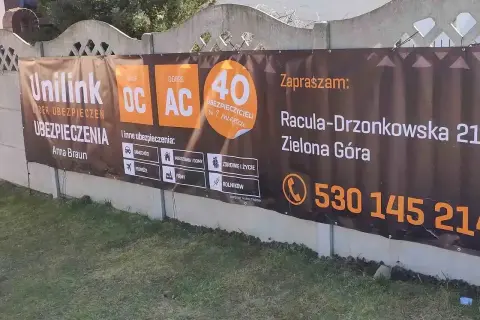 Baner reklamowy firmy ubezpieczeniowej Unilink z informacjami o OC, AC i innych ubezpieczeniach.