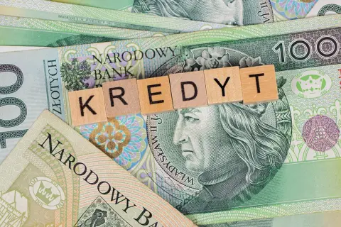 Kredyt dla emeryta 85 lat. Polskie banknoty 100 zł z literami tworzącymi słowo "KREDYT".