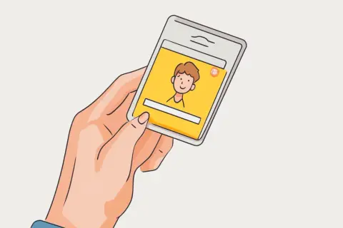 Dłoń trzyma smartfon z żółtym ekranem, na którym widnieje rysunkowa postać. Szybki kredyt na tak przez telefon.