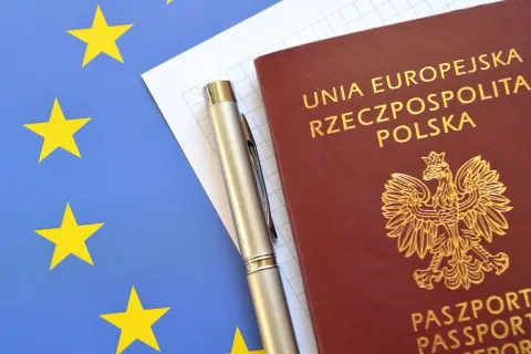 Paszport RP, długopis i kartka papieru na tle flagi UE. Planujesz podróż i zastanawiasz się, jak zastrzec paszport?