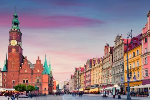 Rynek we Wrocławiu z Ratuszem i kolorowymi kamienicami o zachodzie słońca.