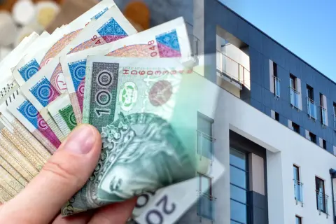 Dłoń trzyma polskie banknoty, symbolizujące kredyt na wkład własny na zakup nowoczesnego mieszkania.