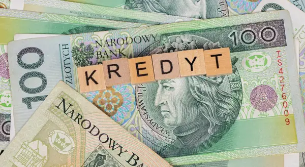 Kredyt dla emeryta 85 lat. Polskie banknoty 100 zł z literami tworzącymi słowo "KREDYT".