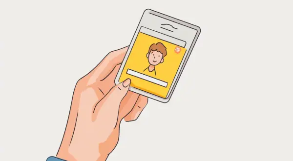 Dłoń trzyma smartfon z żółtym ekranem, na którym widnieje rysunkowa postać. Szybki kredyt na tak przez telefon.
