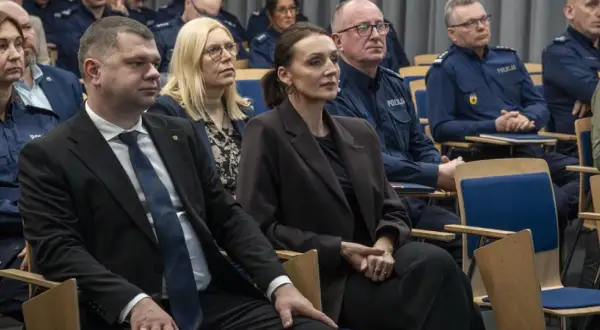 Ludzie w mundurach policyjnych i cywilnych ubraniach siedzą na sali. Dowiedz się, jak sprawdzić numer sprawy na policji.