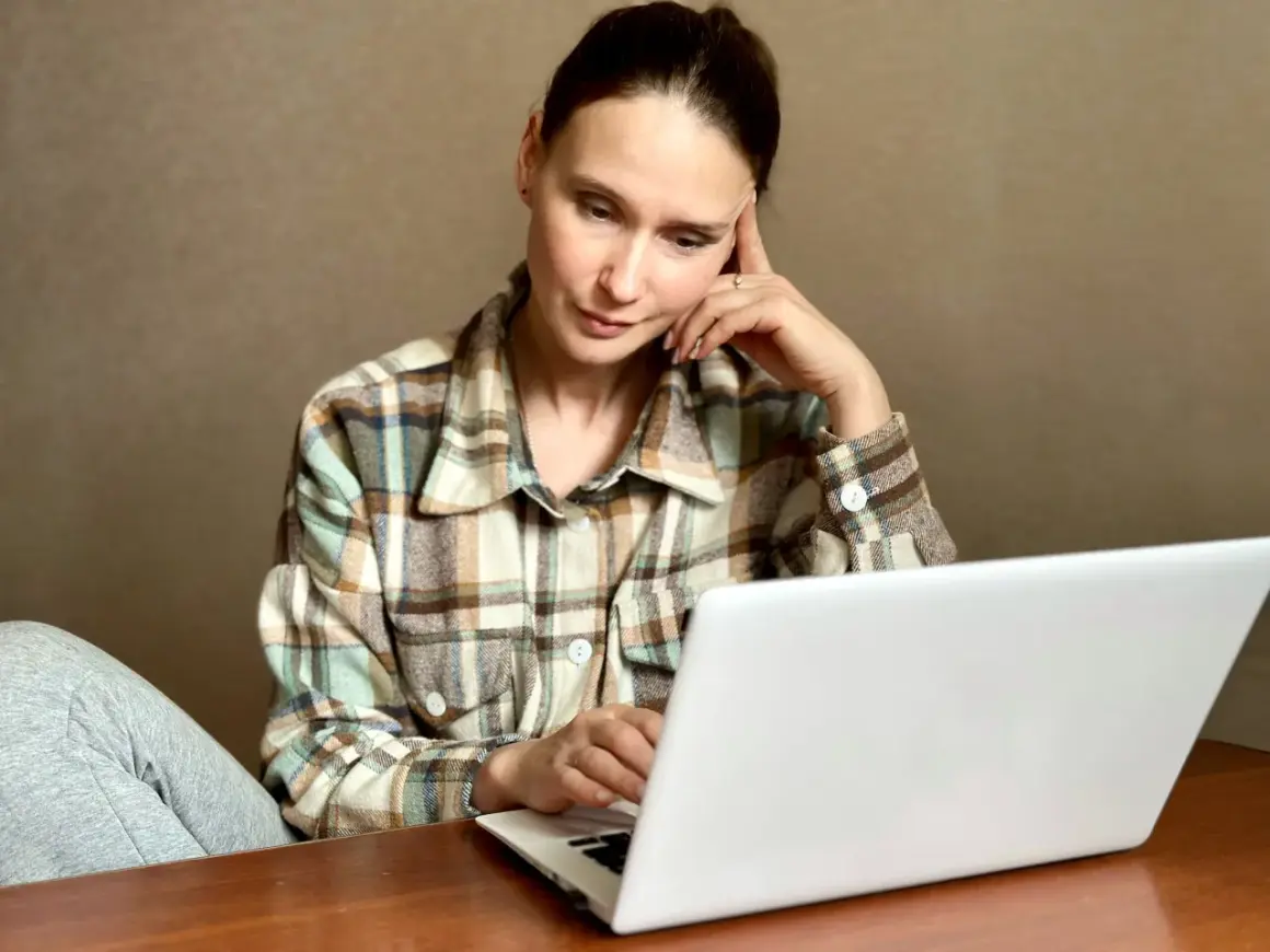 Kobieta zamyślona przy laptopie szuka informacji, jak usunąć negatywny wpis w BIK.