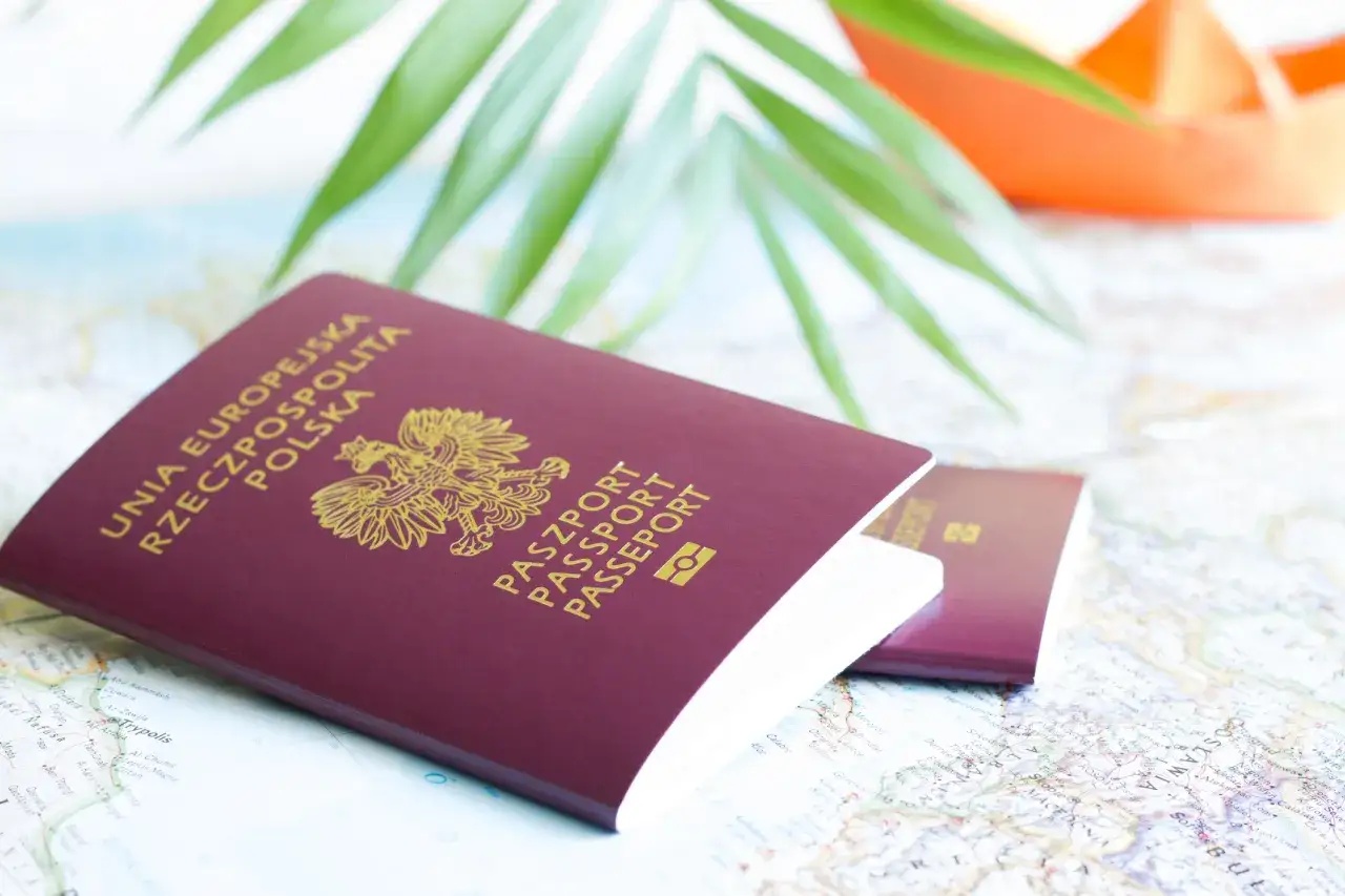Dwa polskie paszporty leżą na mapie. Brak dowodu osobistego za granicą konsekwencje mogą być poważne, zwłaszcza gdy podróżujesz tylko z paszportem.