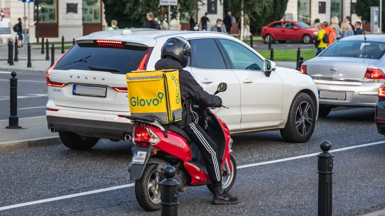 kurier Glovo na skuterze w mieście