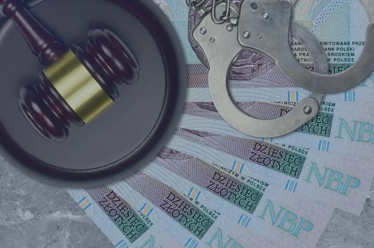 Młotek sędziowski i kajdanki na banknotach 10 zł. Ilustracja sytuacji, kiedy bank zgłasza wyłudzenie kredytu.
