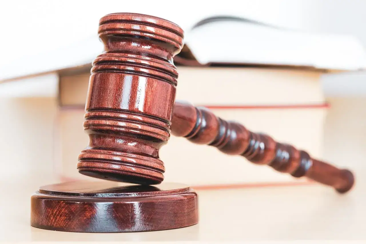 Młotek sędziowski na tle książek. Historia o tym, jak mąż wziął kredyt bez zgody żony i zmarł, może mieć swój finał w sądzie.