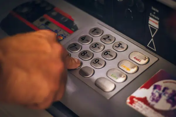 Dłoń wpisuje PIN na klawiaturze bankomatu. Czy numer konta bankowego to dane wrażliwe? Tak, wymaga ochrony.