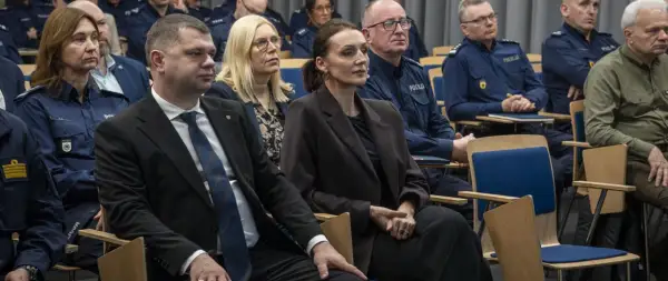 Ludzie w mundurach policyjnych i cywilnych ubraniach siedzą na sali. Dowiedz się, jak sprawdzić numer sprawy na policji.